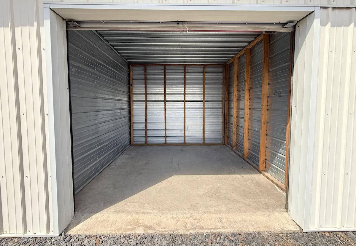 Interior of a 10x10 residential storage unit in Scranton with wooden shelving frame and horizontal metal storage slats, concrete floor, and clear space for personal items